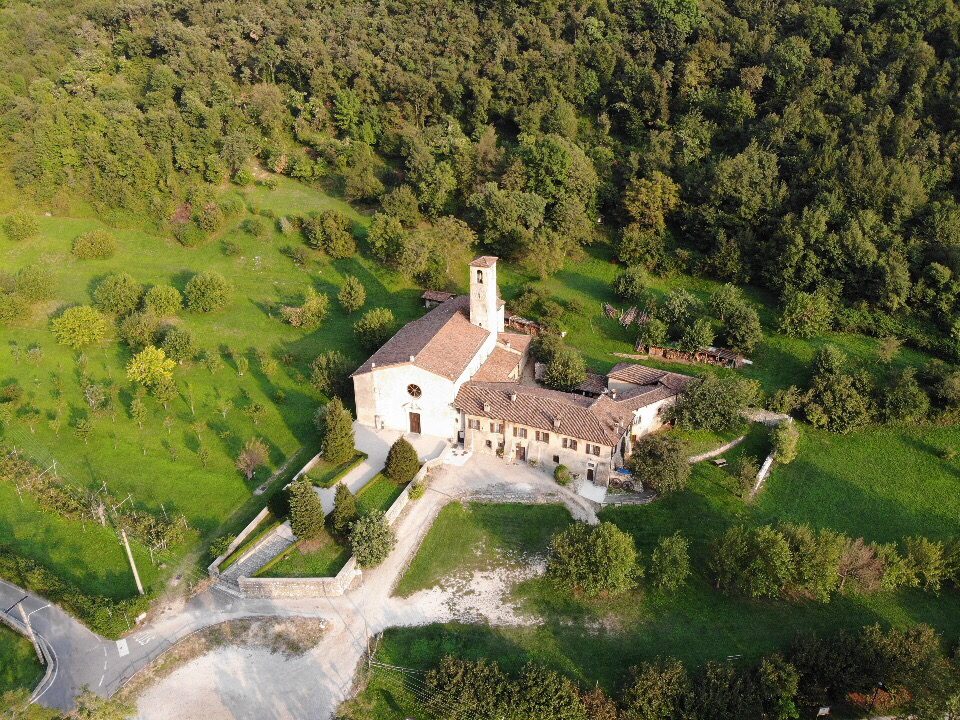 La Pieve adagiata sul pendio, tra prati e boschi